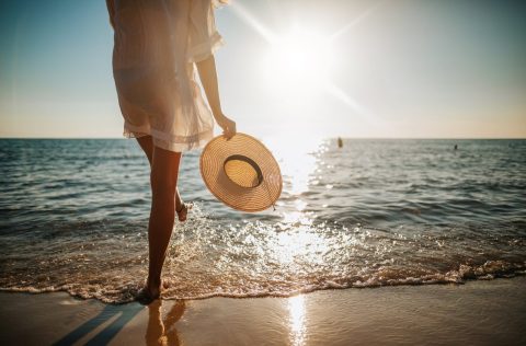 Woman on beach with sun hat