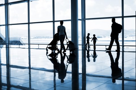 Family at the airport with luggage and a pram