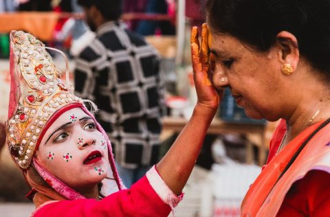 A child applying tika to a woman's forehead in Varanasi