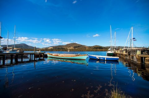 Wooden boats bob on the placid river at Franklin, Tasmania